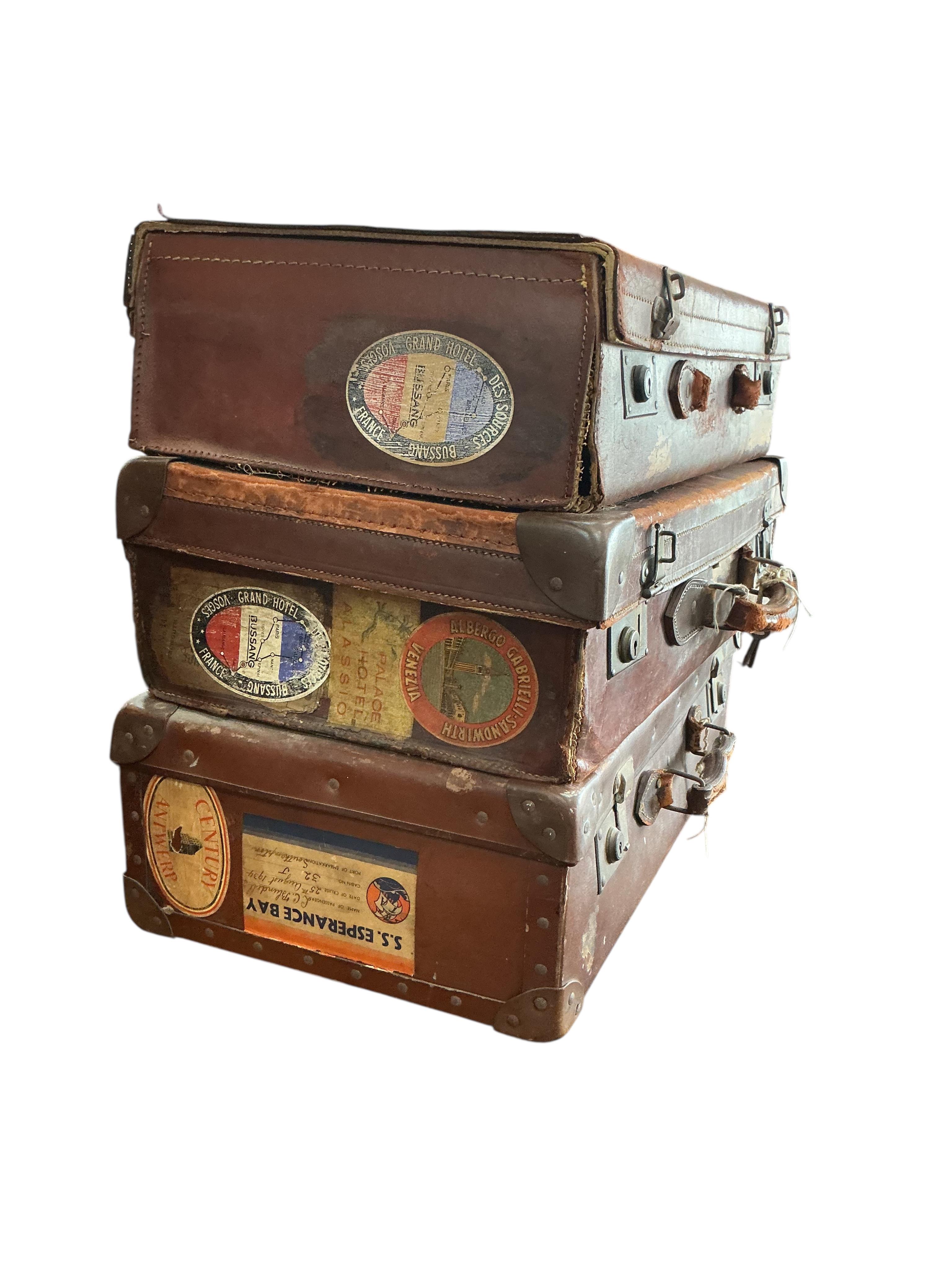 Three vintage suitcases, largest width 66cm